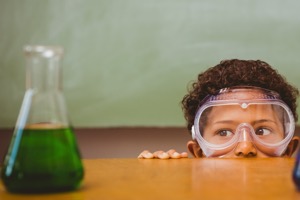 boy looking at flask on table